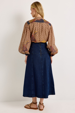 Yuko Denim Skirt in Dark Wash featuring a fitted high waist and softly flared A-line midi silhouette.