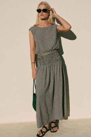 Model wearing the Z Supply Brooke Gingham Skirt in Black with a flowy maxi silhouette and smocked waistband.