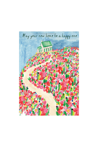 A vertical greeting card featuring a colorful watercolor illustration of a house on a hill covered in pink and red flowers, with a winding cream path and the handwritten text 'May your new home be a happy one' at the top.