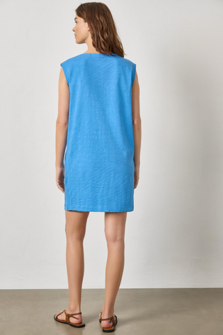 Blue boatneck mini dress with cap sleeves and snap shoulder detail by Lilla P worn with flat sandals