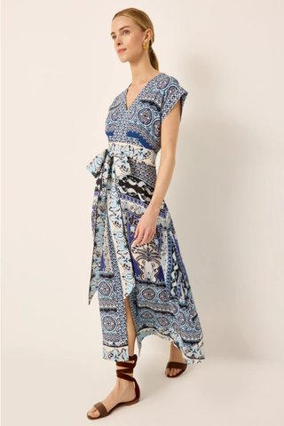 Woman wearing a blue and white patterned dress on a plain background