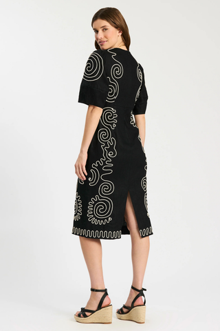 Model wearing Tyler Boe Posey Linen Midi Dress in black linen with white contrast embroidery, lantern sleeves, and midi silhouette