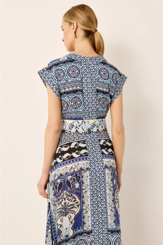 Woman wearing a patterned dress with a neutral background