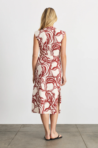 Woman wearing a red and white patterned dress on a plain background