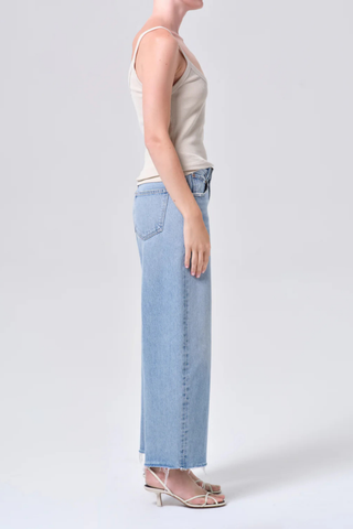 AGOLDE Low Curve Fray Jean in Force featuring a low-rise fit with a curved leg and raw frayed hem in a light wash