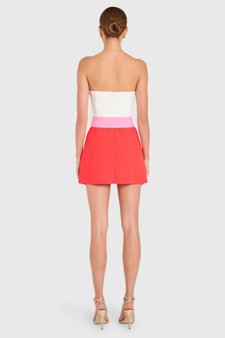 Amanda Uprichard Fae Romper in ivory and crimson strapless color-block design with wide belt and A-line silhouette