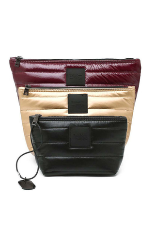 Think Royln Travel Trio set of three quilted pouches in burgundy, pearl, and black.
