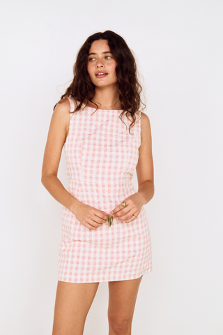 Model wearing the MINKPINK Sabina Tie Back Mini Dress in Pink Gingham featuring a fitted bodice, tie-back detail, and classic pink gingham print.