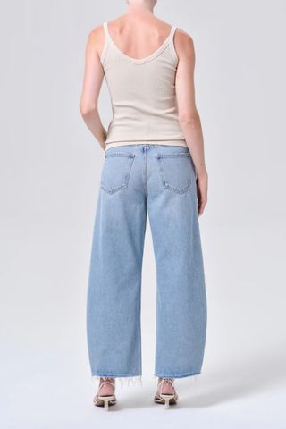AGOLDE Low Curve Fray Jean in Force featuring a low-rise fit with a curved leg and raw frayed hem in a light wash