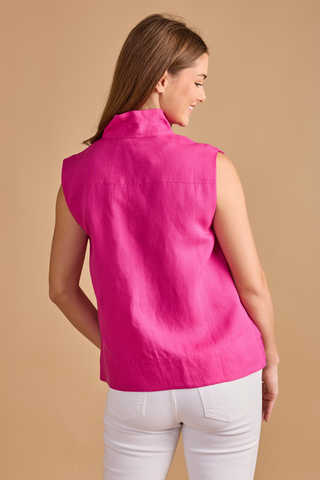 Model wearing the Double A Sandy Top in Fuchsia featuring a sleeveless silhouette, stand collar, split neckline, and relaxed fit paired with white denim