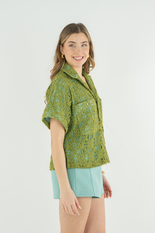 Model wearing the Emily McCarthy Luna Top in Olive Hour featuring olive lace overlay, aqua lining, button-front closure, short sleeves, and a relaxed resort-inspired silhouette