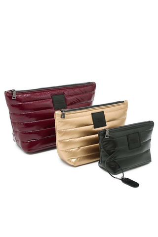 Think Royln Travel Trio set of three quilted pouches in burgundy, pearl, and black.