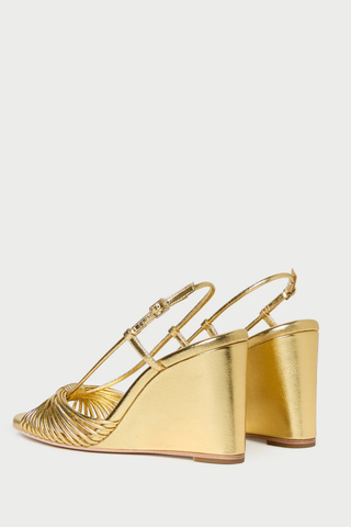 Loeffler Randall Marren Wedge in gold metallic leather featuring knotted mignon toe straps, slingback strap, open toe, and 3.5-inch wedge heel