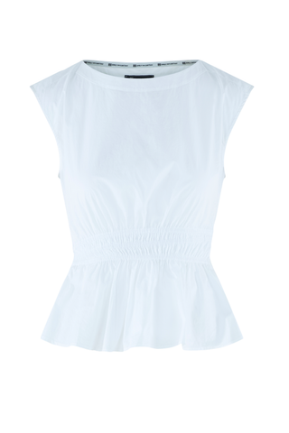 Model wearing the Emily McCarthy Aria Top in White with a sleeveless silhouette and peplum hem.