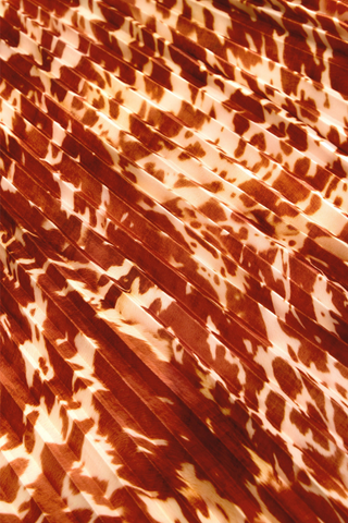 Wesley Skirt in Calico featuring a red and ivory printed pleated maxi silhouette with a contrasting auburn waistband.