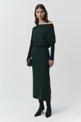 SIMKHAI Janese Off Shoulder Midi Dress in deep Everglade green with long sleeves, a fitted waist, and straight midi skirt.