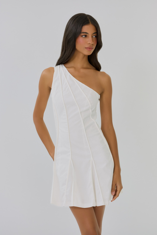 Model wearing the Hutch Nadetta Dress in White featuring a one-shoulder neckline, paneled seam detailing, structured bodice, and flared mini skirt paired with strappy white heels