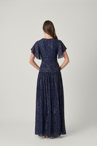 Shoshanna Lilly Dress in Indigo Silver and Gold featuring shimmering lurex chiffon, a V-neckline, flutter sleeves, ruched waist, and flowing full-length skirt.