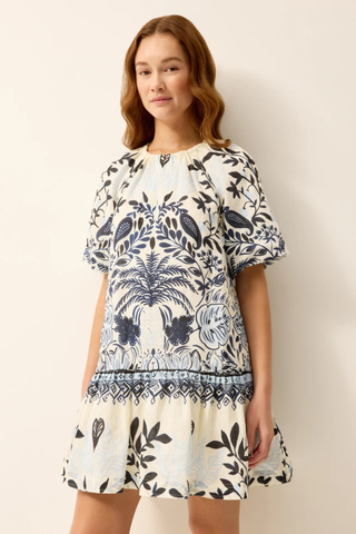Woman wearing a floral dress against a plain background