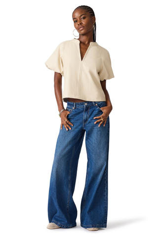 Bone blouse with flutter sleeves and a relaxed draped silhouette.