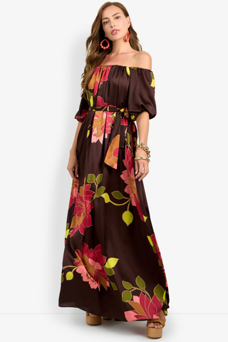 Trina Turk Voglia Dress in Multi featuring a bold floral print, off-the-shoulder neckline, puff sleeves, sash waist, and flowing maxi silhouette.