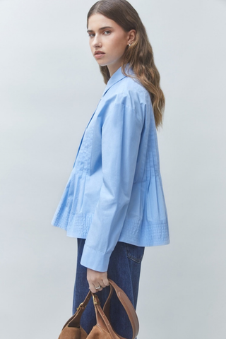 Suncoo Loeli Blouse in Bleu Ciel featuring a light blue hue, gathered high neckline, long sleeves, and flowy silhouette.
