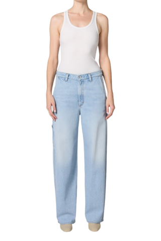 Model wearing the AGOLDE Lyndon Jean in Memory featuring a relaxed straight leg silhouette, oversized utility pockets, and a soft light wash denim paired with a fitted neutral tank top