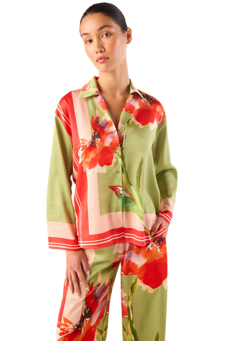 Model wearing the MISA Jaya Top in Scarf Flora Satin featuring a vibrant floral print, satin fabric, button-front closure, long sleeves, and relaxed draped fit paired with coordinating pants