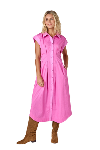 Model wearing the Crosby Quincey Dress in Poppy Pink with a midi shirt dress silhouette and waist tie.