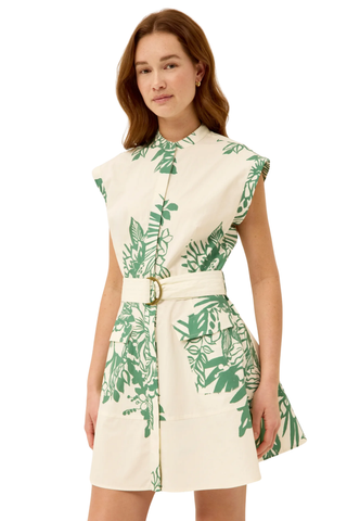 Woman wearing a white dress with green leaf pattern on a white background