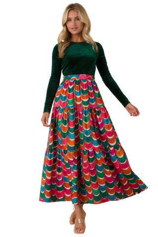 Prosperina Fontaine Maxi Dress in Party Planner featuring a deep emerald green long-sleeve bodice and a full flowing maxi skirt in a vibrant multicolor geometric print.