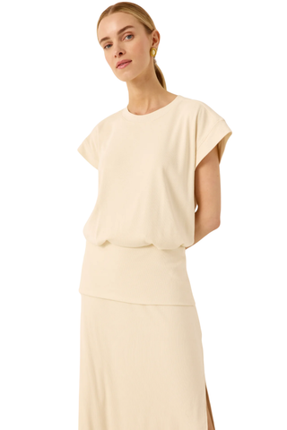 Woman wearing a beige dress with a plain background