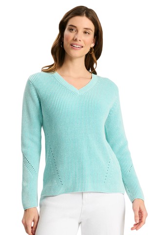 A woman wearing a light aqua ribbed knit V-neck sweater with long sleeves and white pants, photographed against a plain white background.