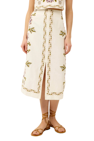 Ivory midi skirt with floral embroidery and front slit.