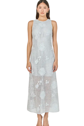 Woman wearing a light blue sleeveless dress with floral pattern on a white background