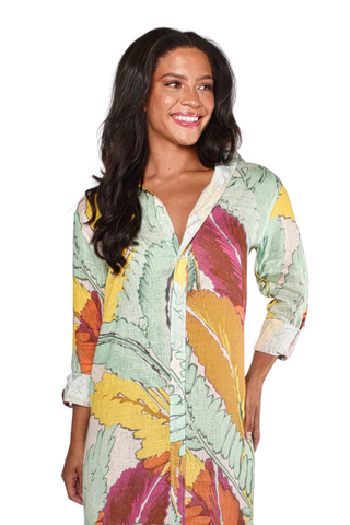 Woman wearing a yellow and pink botanical print midi dress with button front, collar, and rolled sleeves by Emily Phillips on a white background.