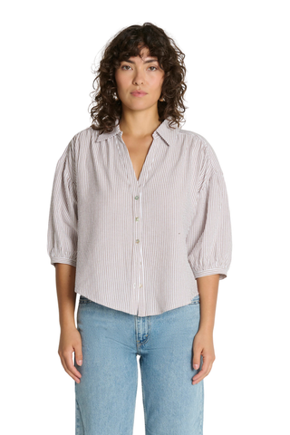 Model wearing the Nation LTD Jaynee Blouse in Praline Stripe, a lightweight striped button-front blouse featuring a relaxed fit, classic collar, three-quarter sleeves, and a breezy textured woven fabric.