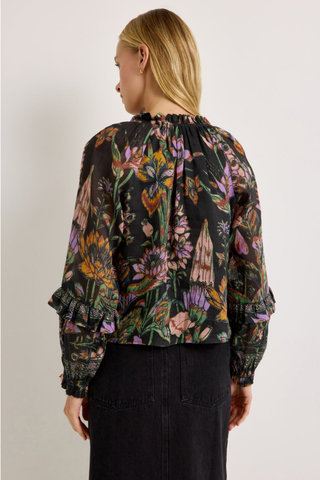 Marie Oliver Umika Top in Nightshade featuring a dark floral print, V-neckline, ruffle details, and long fluid sleeves.
