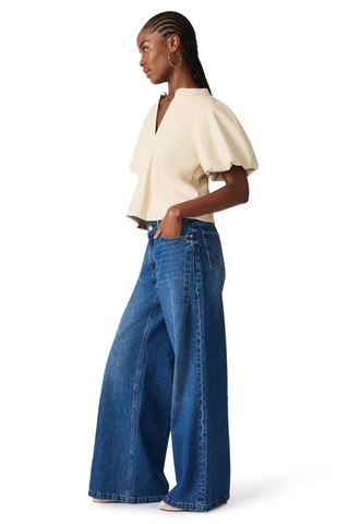 Bone blouse with flutter sleeves and a relaxed draped silhouette.
