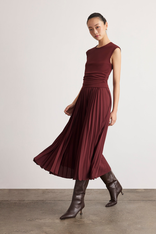 Tanya Taylor Carly Dress in Deep Redwood burgundy with cap sleeves, a ruched fitted waist, and flowing pleated midi skirt.