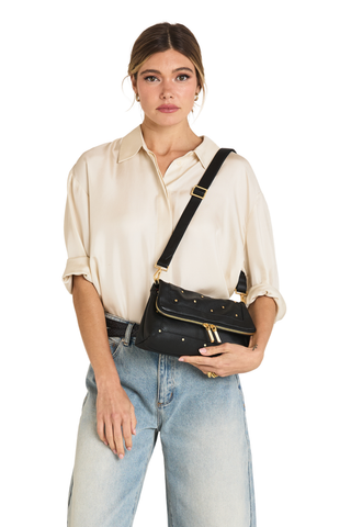Hammitt Beverly Medium Handbag in Starlight featuring black pebbled leather, mini rivet accents, brushed gold hardware, and an elongated shoulder bag silhouette.