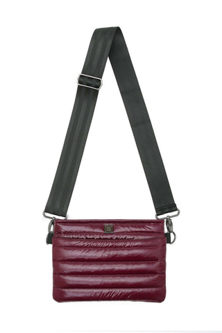 Shop the Think Royln Bum Bag 2.0 in Glossy Deep Burgundy, a lightweight quilted bag with adjustable straps and hands-free versatility.