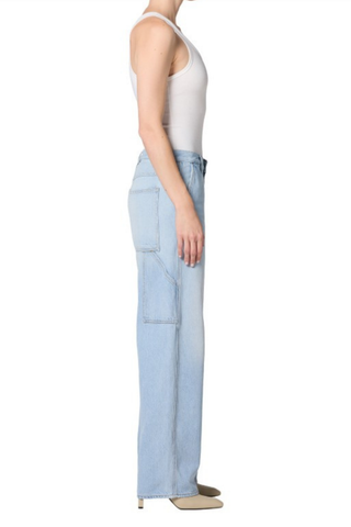 Model wearing the AGOLDE Lyndon Jean in Memory featuring a relaxed straight leg silhouette, oversized utility pockets, and a soft light wash denim paired with a fitted neutral tank top