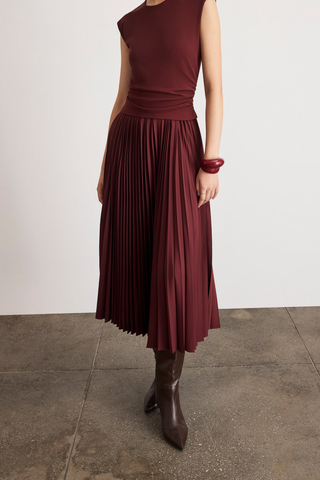 Tanya Taylor Carly Dress in Deep Redwood burgundy with cap sleeves, a ruched fitted waist, and flowing pleated midi skirt.