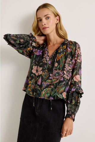 Marie Oliver Umika Top in Nightshade featuring a dark floral print, V-neckline, ruffle details, and long fluid sleeves.
