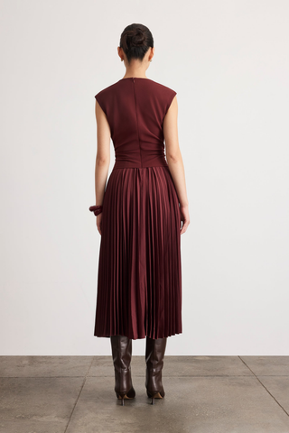 Tanya Taylor Carly Dress in Deep Redwood burgundy with cap sleeves, a ruched fitted waist, and flowing pleated midi skirt.