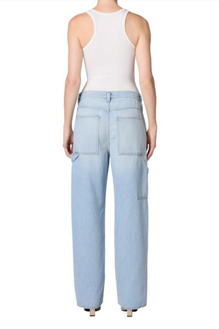 Model wearing the AGOLDE Lyndon Jean in Memory featuring a relaxed straight leg silhouette, oversized utility pockets, and a soft light wash denim paired with a fitted neutral tank top