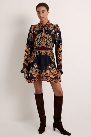 Thalia Dress in Lasso featuring a navy Western-inspired print, long sleeves, ruffle detailing, and a handkerchief mini hem.