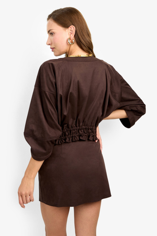 Trina Turk Prita 2 Jacket in Cioccolato featuring a cropped chocolate brown suedette silhouette with wide sleeves and a smocked waist.