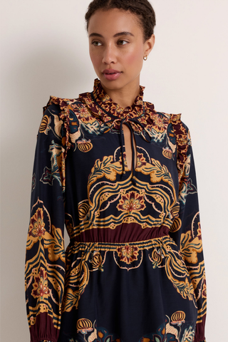 Thalia Dress in Lasso featuring a navy Western-inspired print, long sleeves, ruffle detailing, and a handkerchief mini hem.